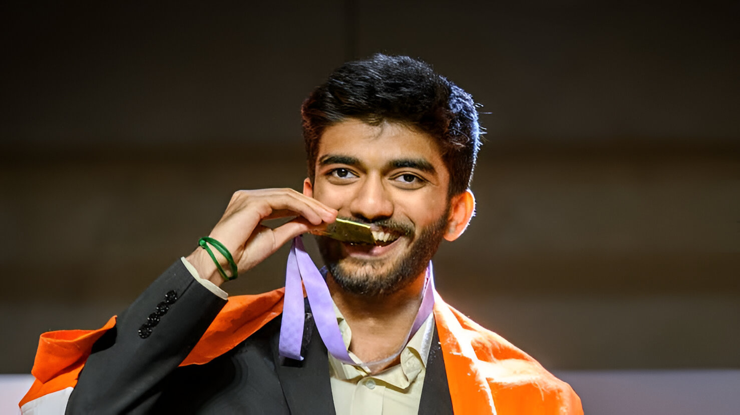 Gukesh kissing his medal.